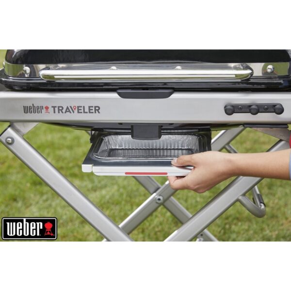 Barbacoa portátil Weber Traveler en uso exterior.