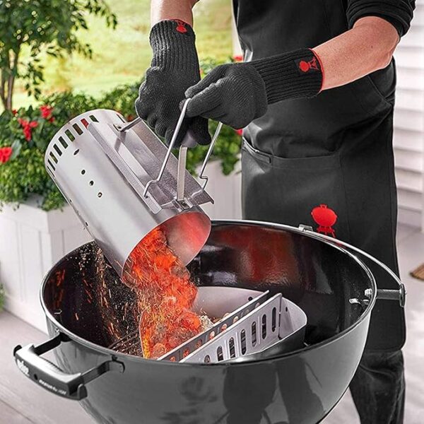 Vertiendo carbón encendido en barbacoa con guantes