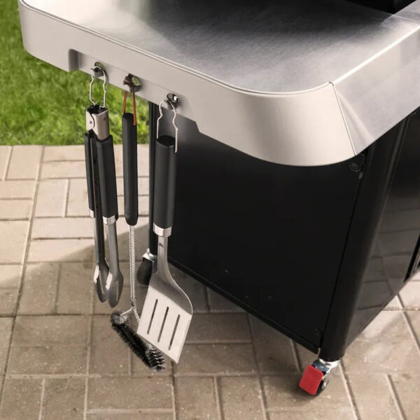 Utensilios de barbacoa colgados en una parrilla.