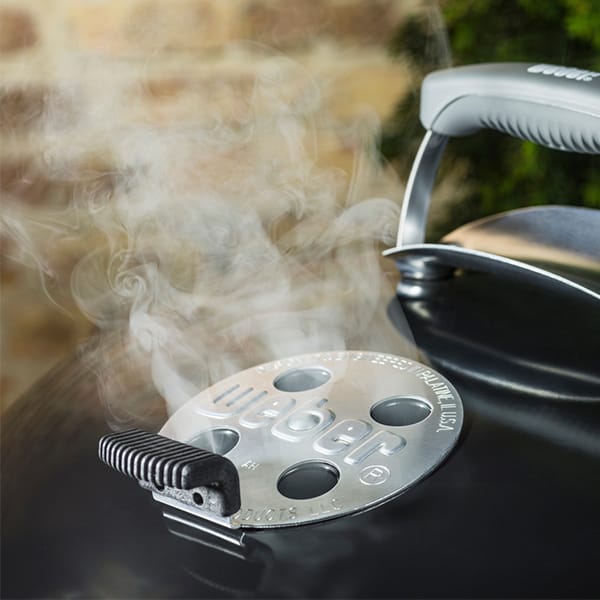 Barbacoa Weber emitiendo humo al cocinar
