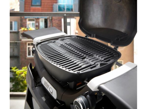 Parrilla portátil en balcón de apartamento urbano.