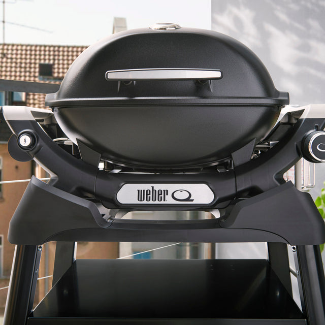 Barbacoa negra Weber en terraza soleada.