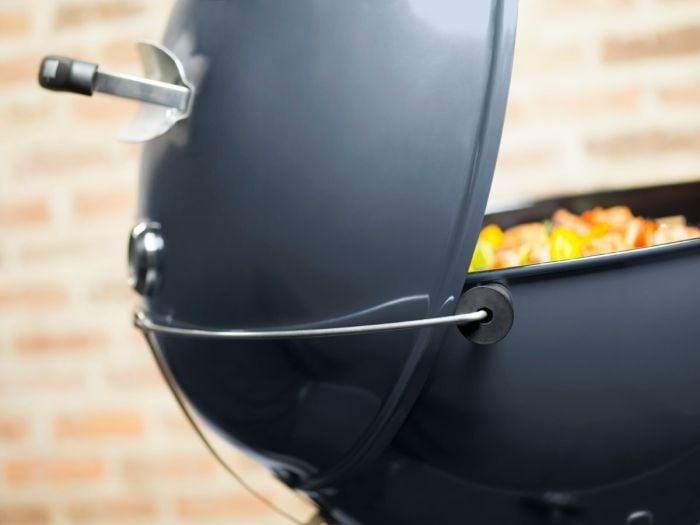Barbacoa abierta con comida en el interior