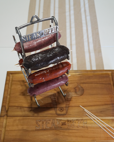 Parrilla con salchichas variadas sobre tabla de madera.