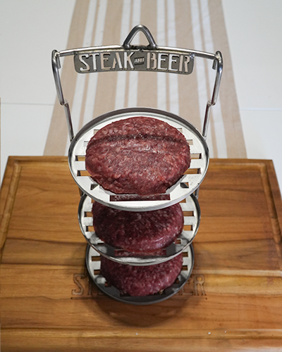 Carne cruda en soporte de metal sobre tabla.