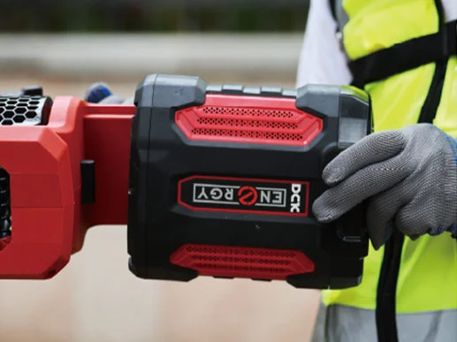 Batería portátil roja y negra en mano enguantada