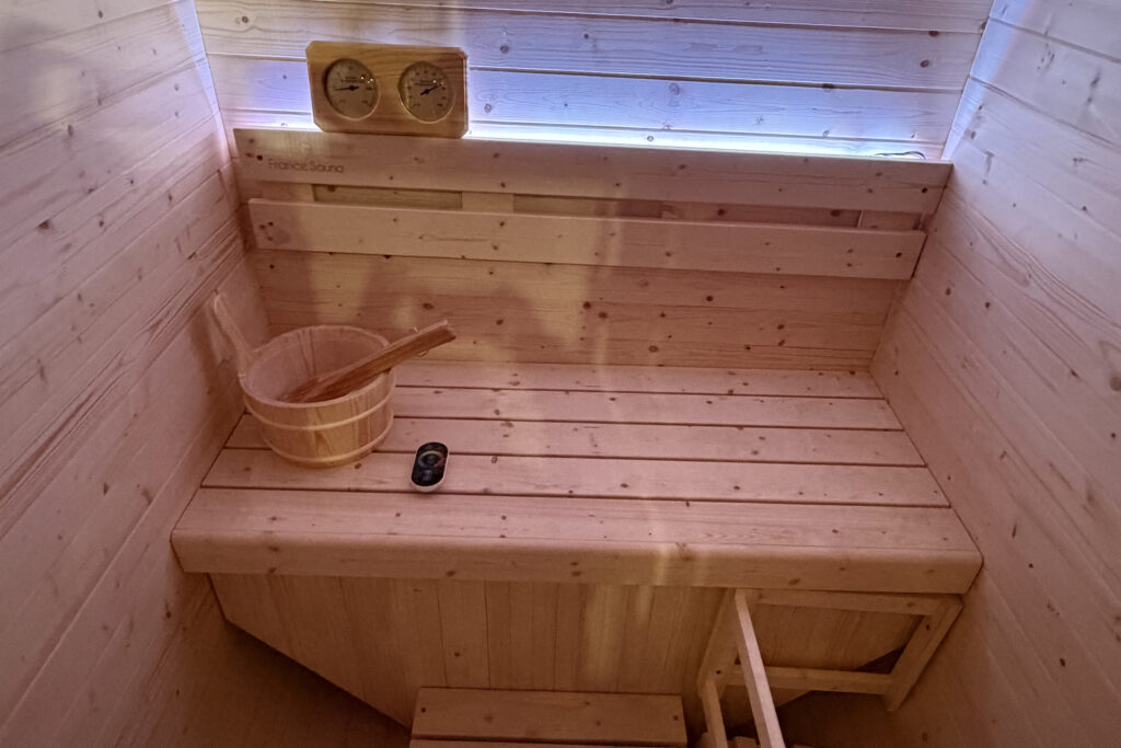 Interior de sauna de madera con cubo y termómetro