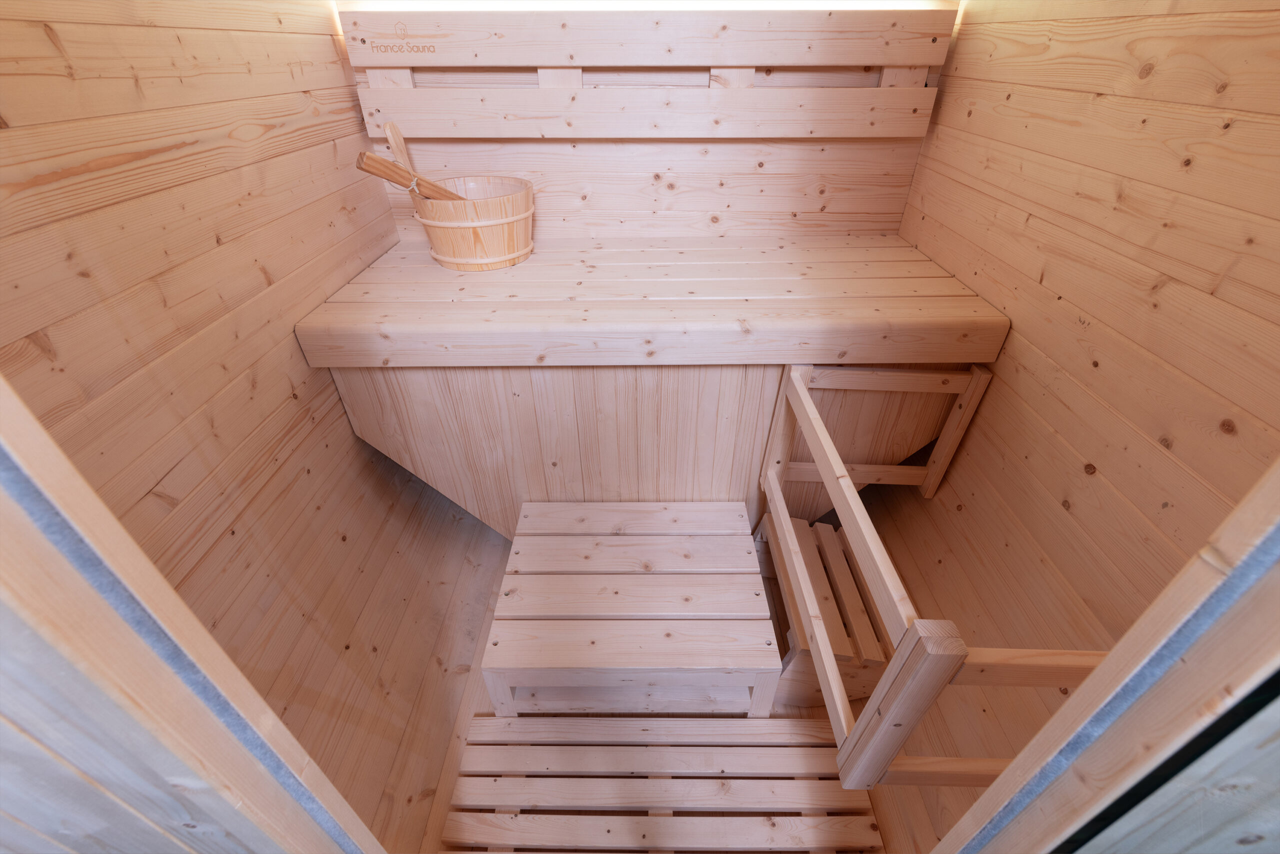 Interior de sauna de madera con banco y cubo