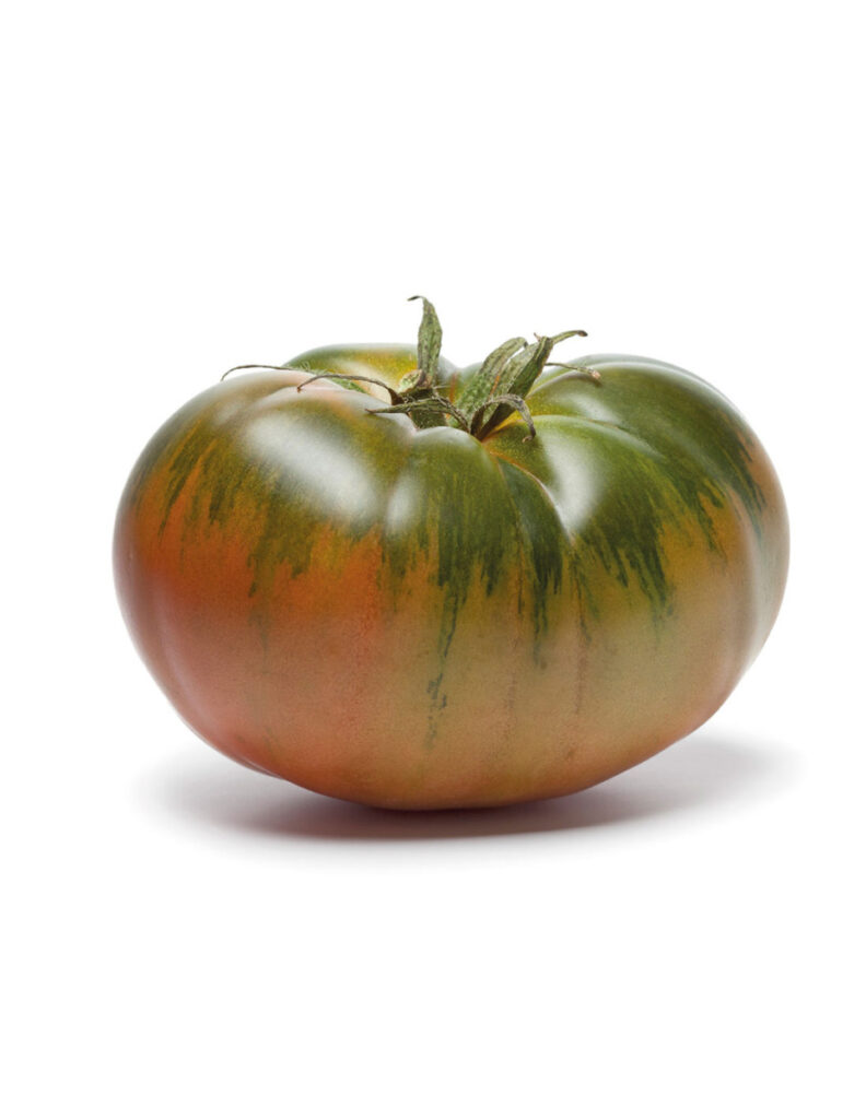 Tomate grande verde y rojizo sobre fondo blanco