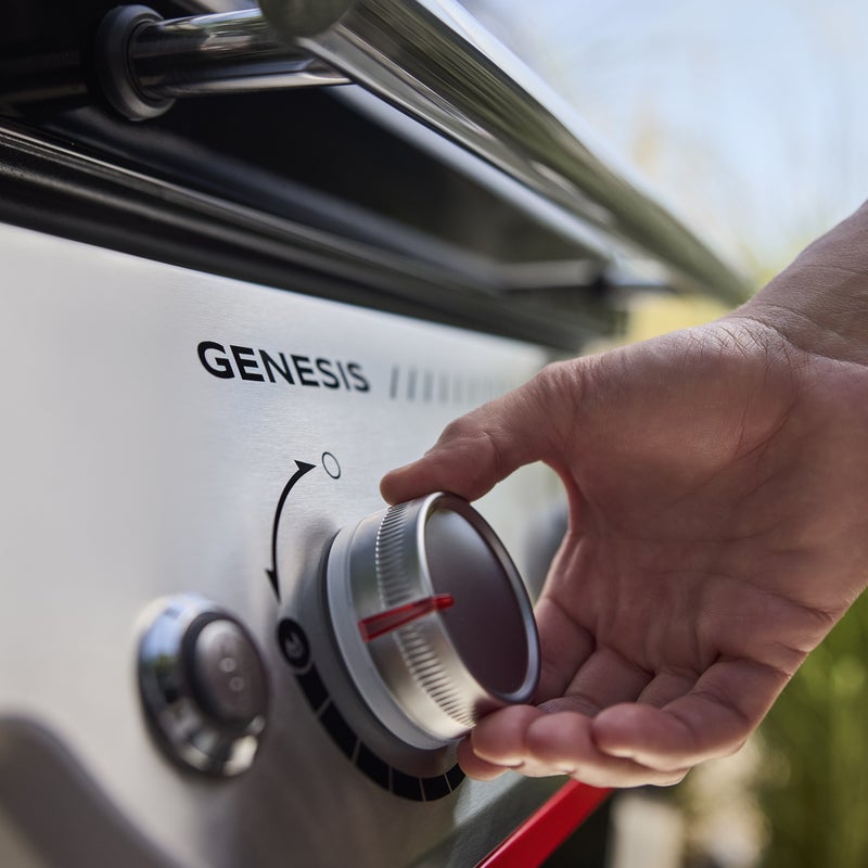 Mano ajustando mando de barbacoa Genesis