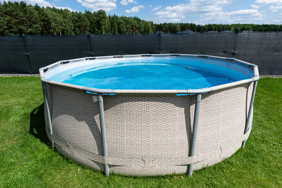 Piscina desmontable redonda en jardín con césped