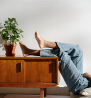Piernas sobre mueble con plantas y tacones