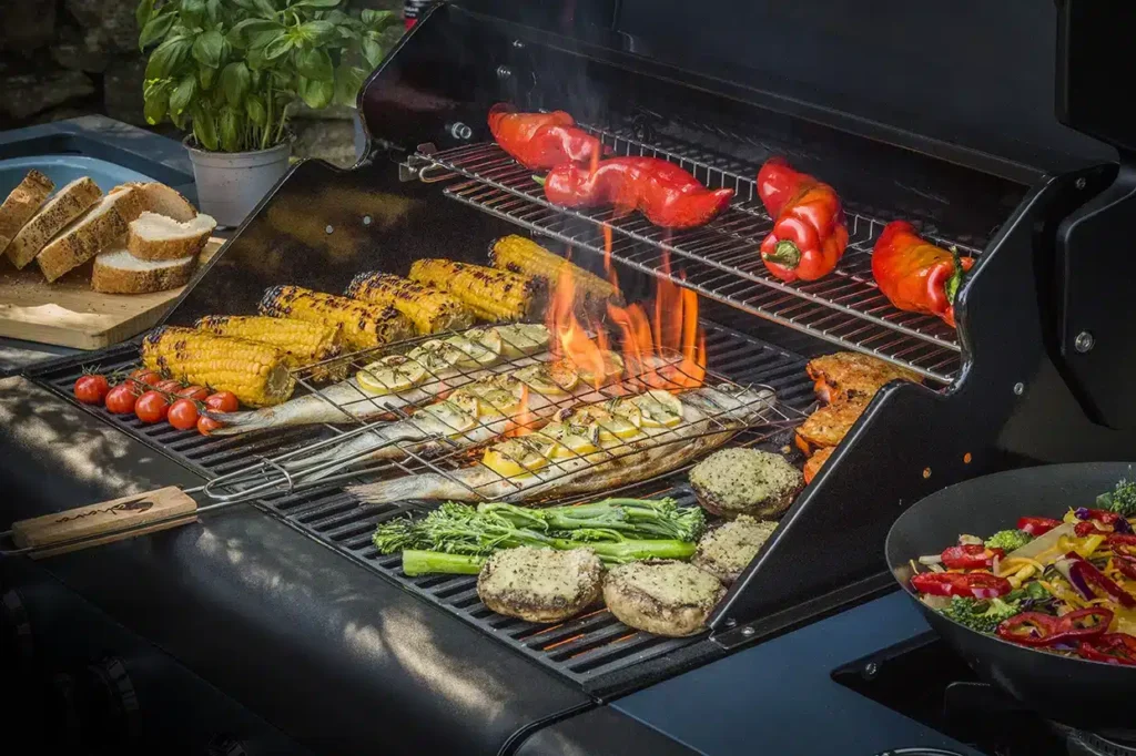 Barbacoa con verduras asándose sobre parrilla encendida