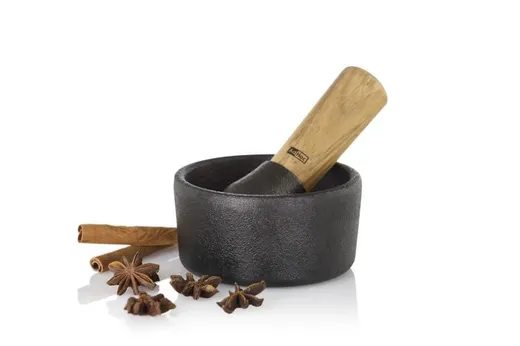 Mortero negro con mano y especias aromáticas
